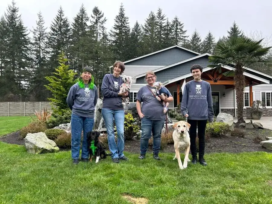 Friendly Grove staff with dogs on the lawn in front of the resort in Olympia, WA